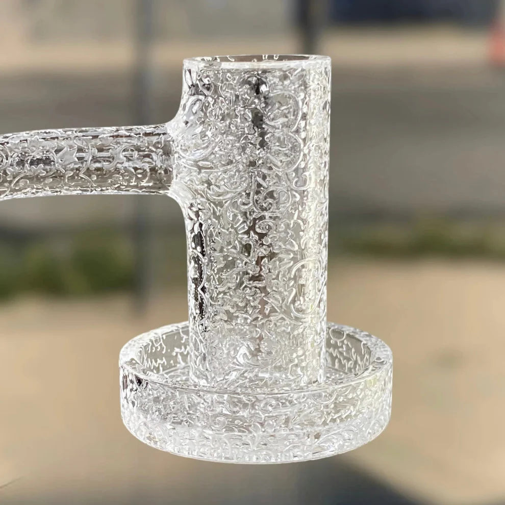 Close-up of a Gee West engraved banger with high-purity quartz and a decorative shredder etching.