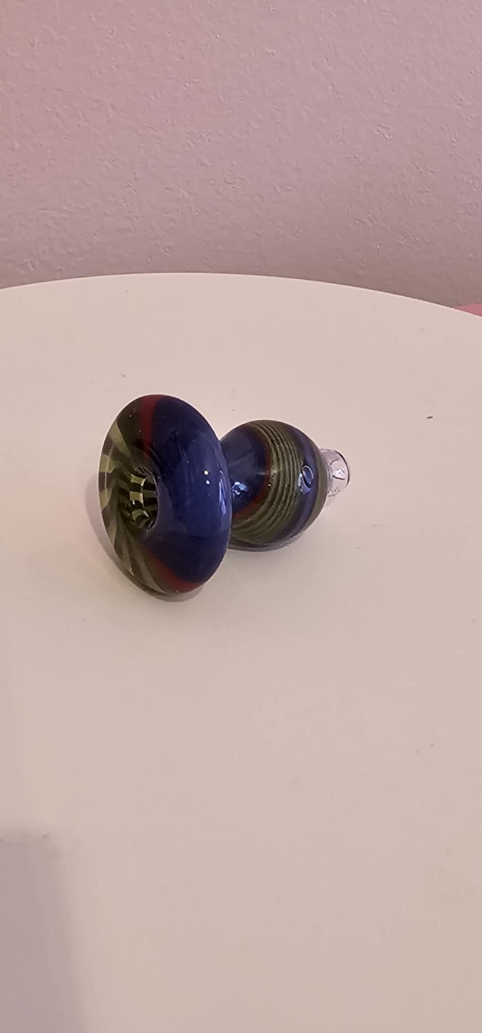 hand placing a glass bubble carb cap onto a heated quartz banger on a dab rig during a session