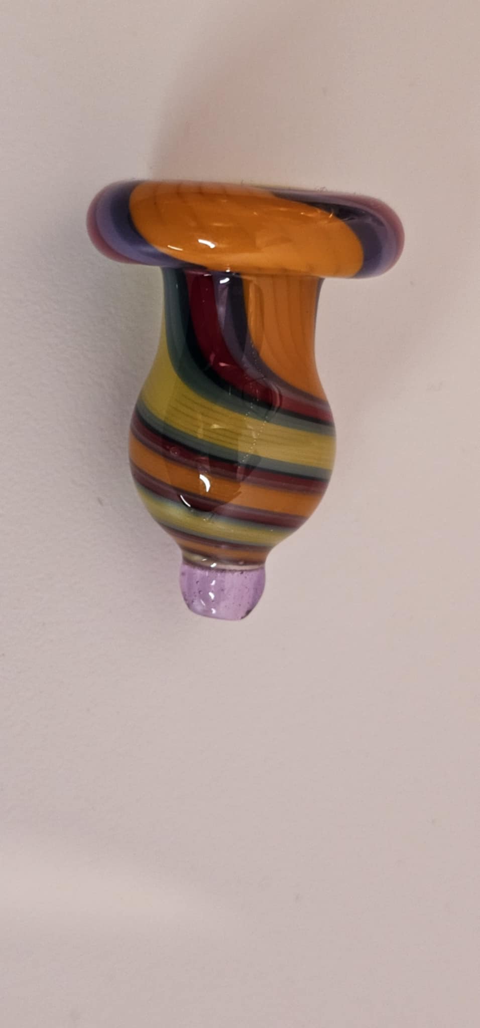 close-up of multicolor glass swirl pattern showing orange black red green and yellow blending in borosilicate glass