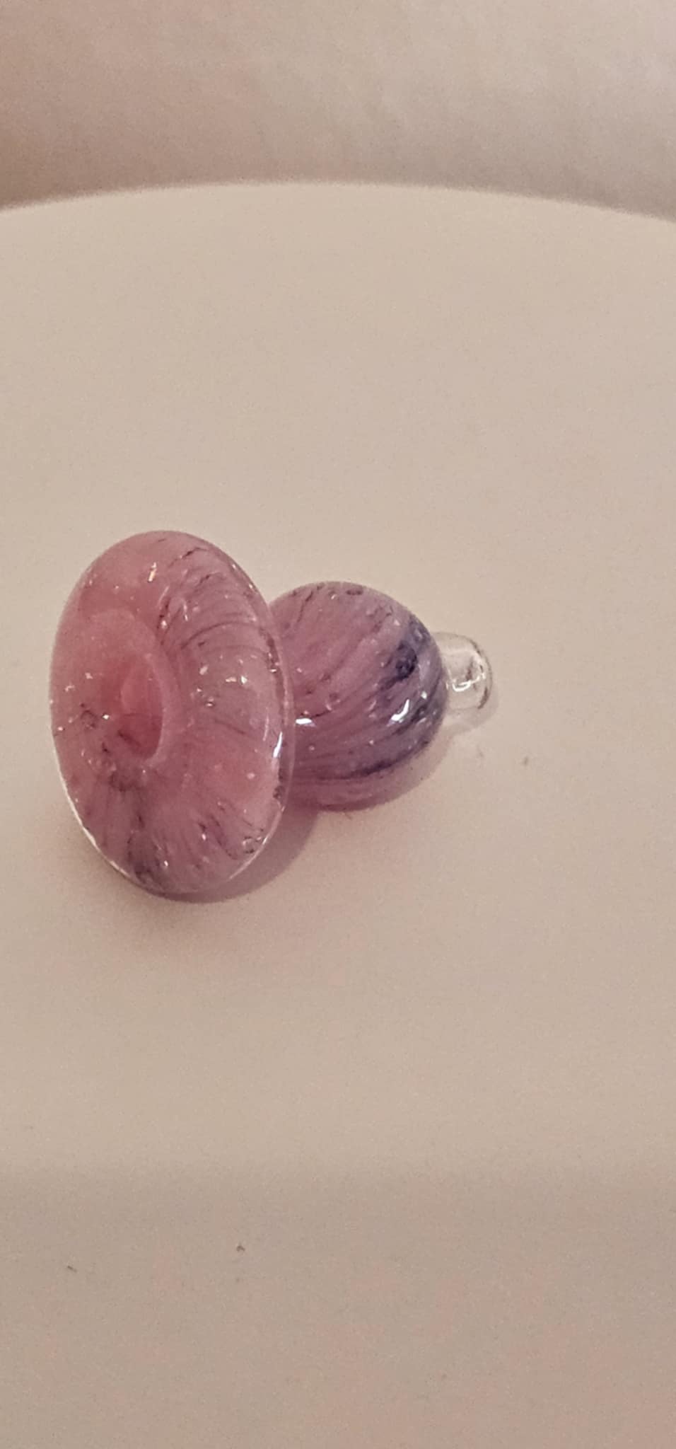 Pink purple sparkle bubble carb cap rotating on quartz banger while vapor is drawn through dab rig during low-temp dab session